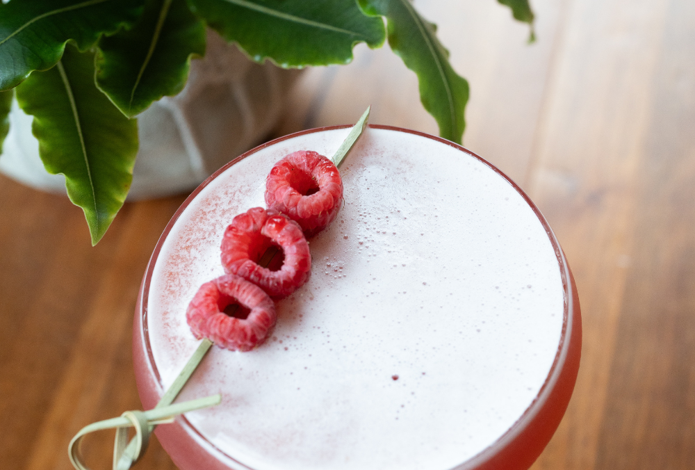 Pink cocktail with raspberry on top