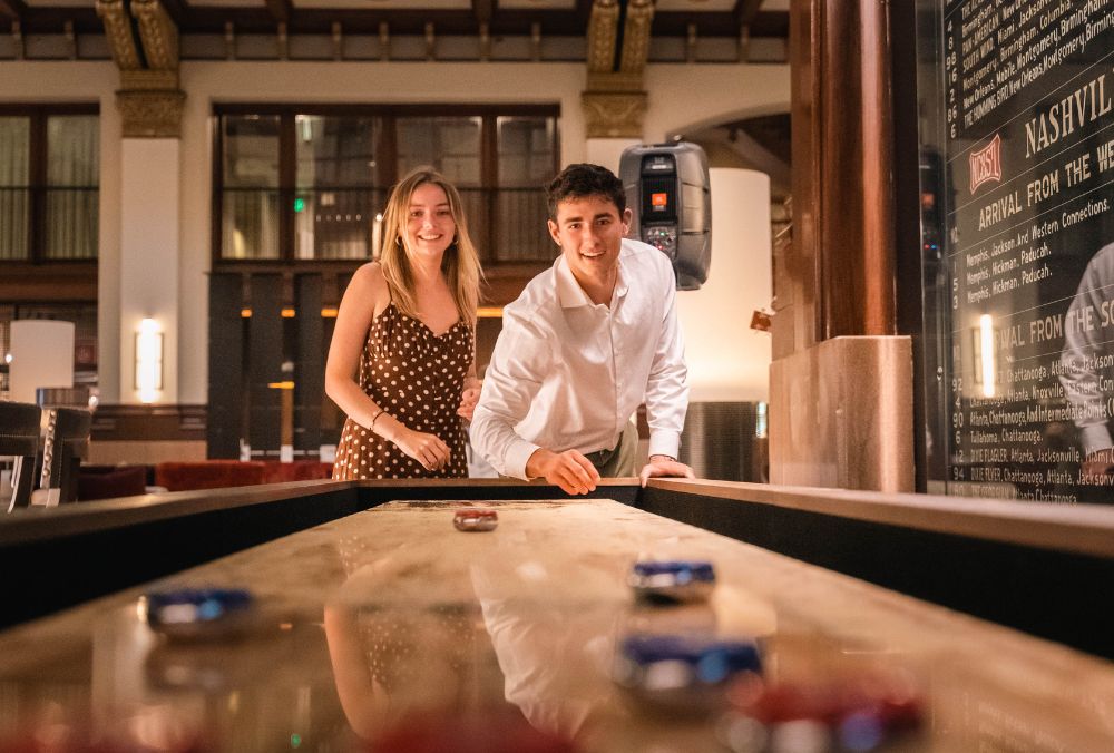 Couple playing in a shuffleboard table