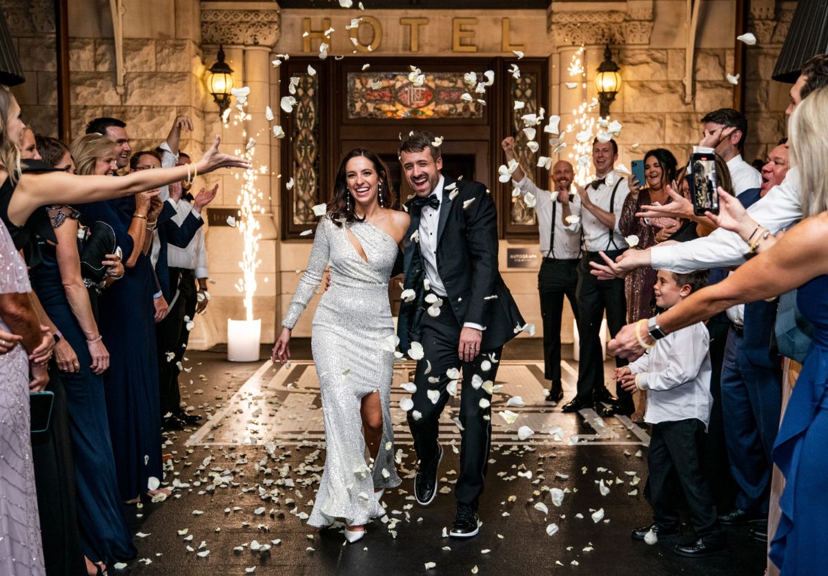 Bride and groom exiting wedding with guests throwing petals