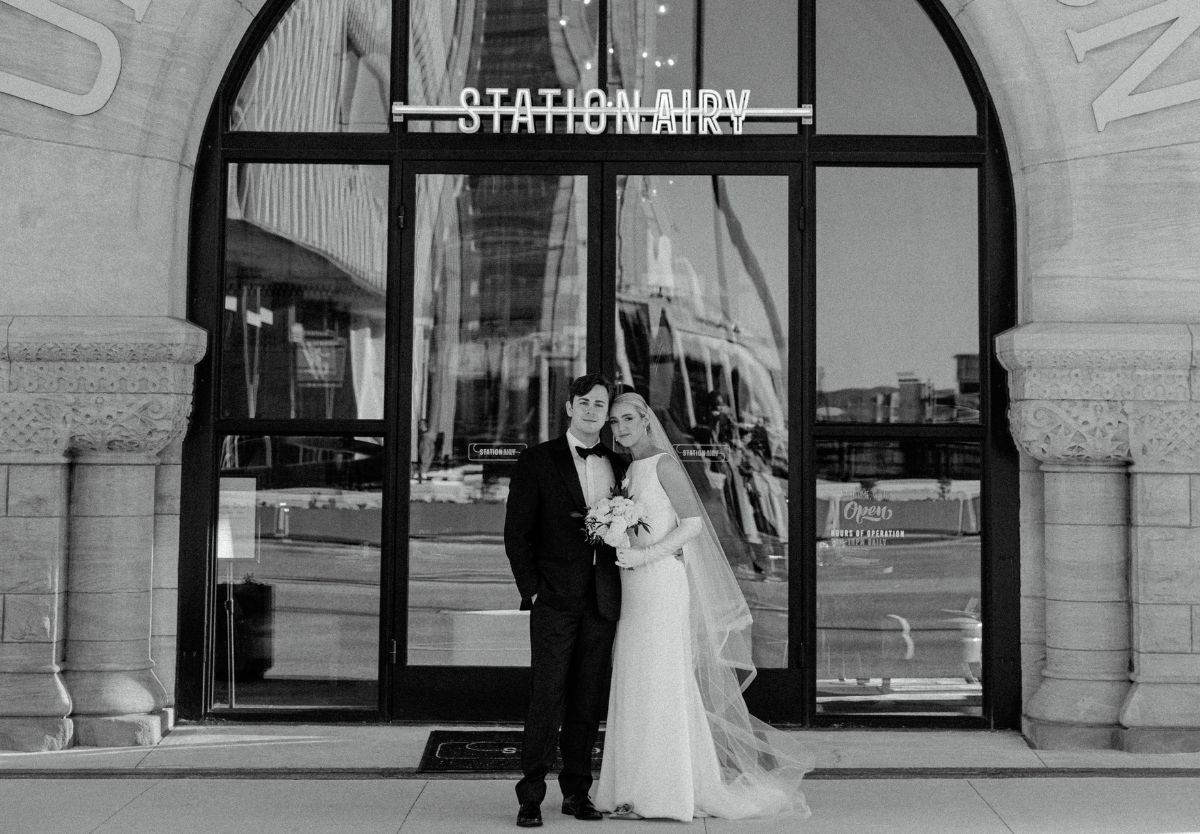 Bride and groom posing in front of Stationairy